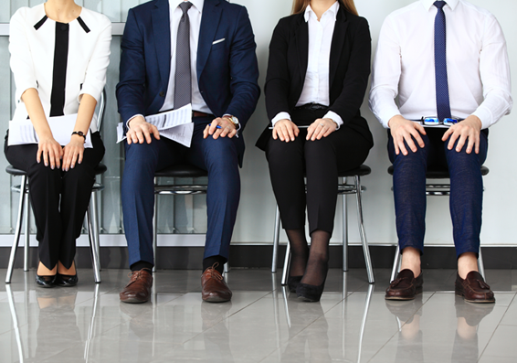 People sitting on a set of stools waiting for an interview